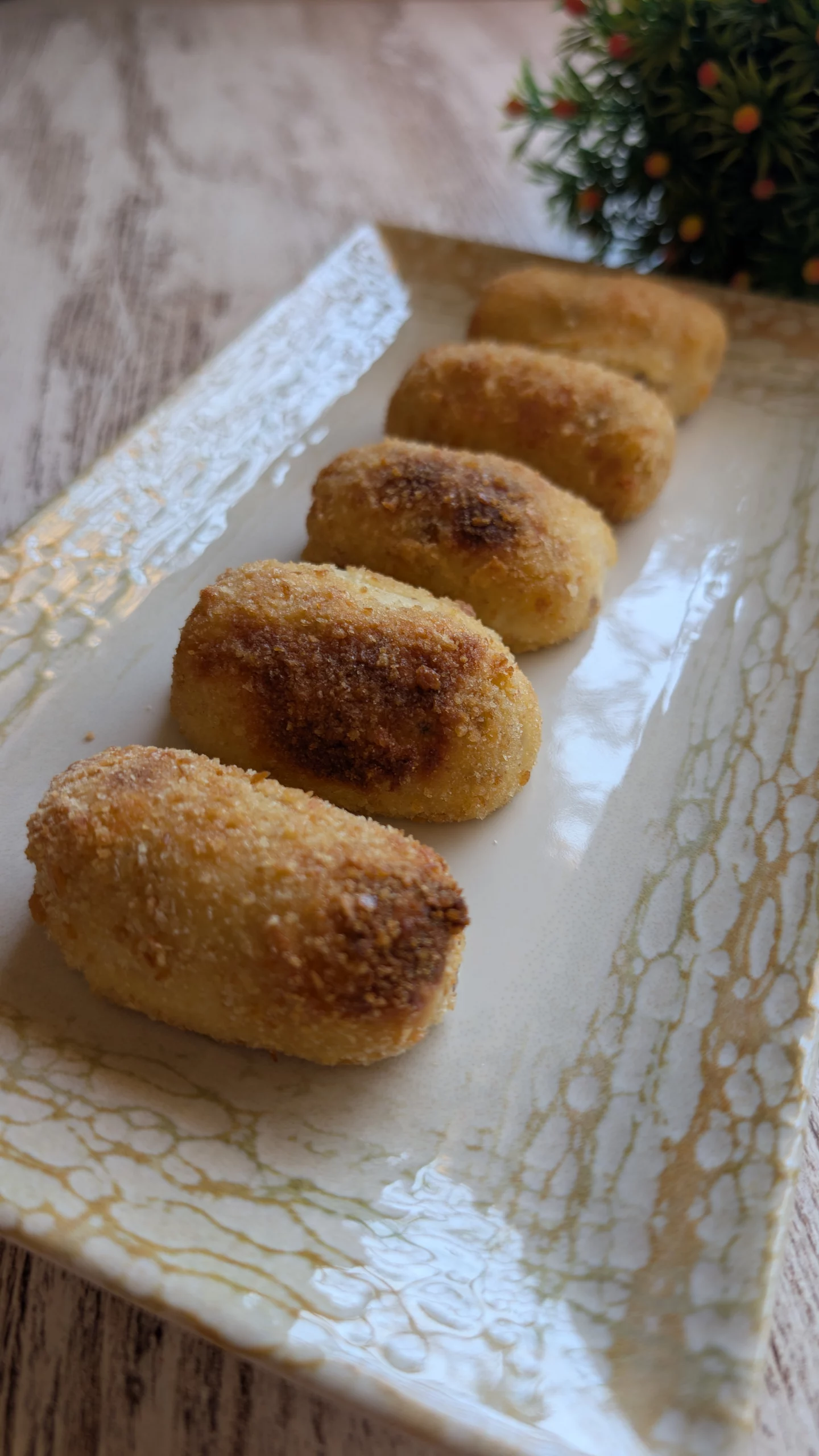 Croquetas caseras de puchero doradas sobre una bandeja, crujientes por fuera y cremosas por dentro, listas para servir