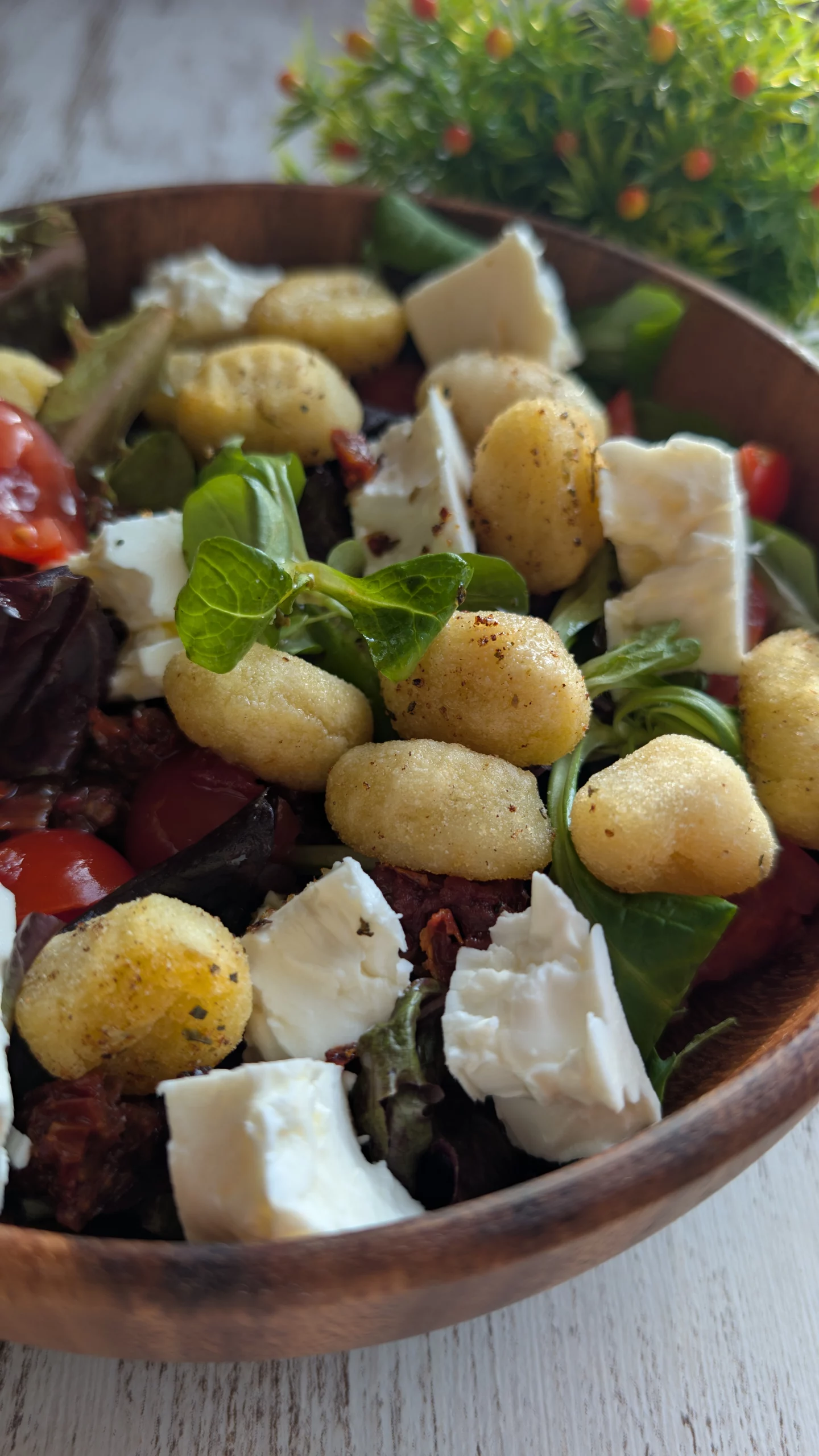 Ensalada templada con ñoquis crujientes al aire, brotes verdes, tomates cherry, tomate seco y queso feta.