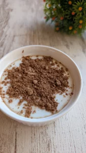 Bol de avena nocturna con yogur griego, semillas de chía, avena y cacao en polvo.