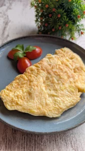 Tortilla casera de puerro hecha con huevos, sal y puerro picado, servida en un plato lista para comer