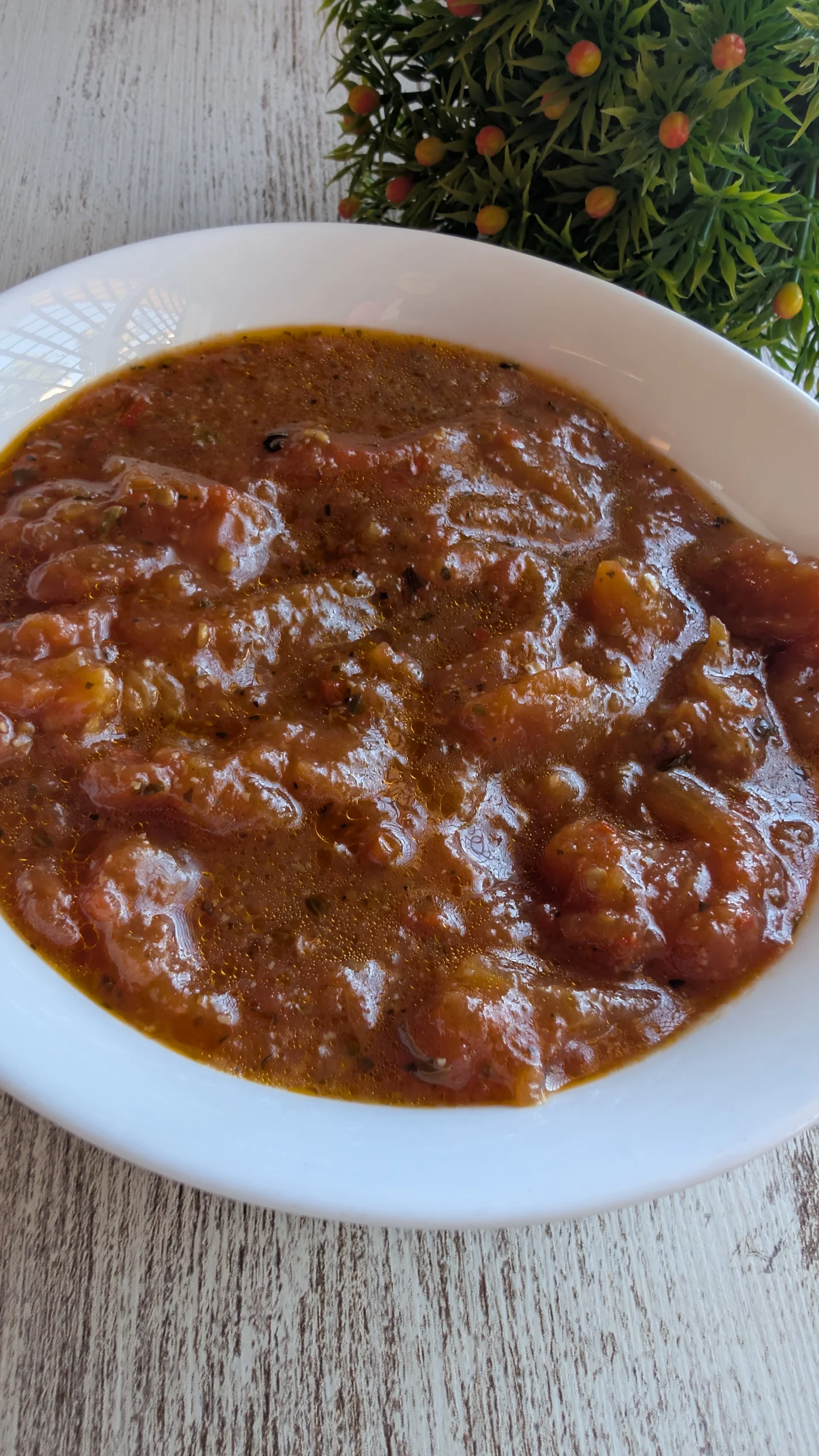 Salsa de tomate casera exprés en una sartén, con trozos de tomate fresco, aceite de oliva virgen extra y especias.
