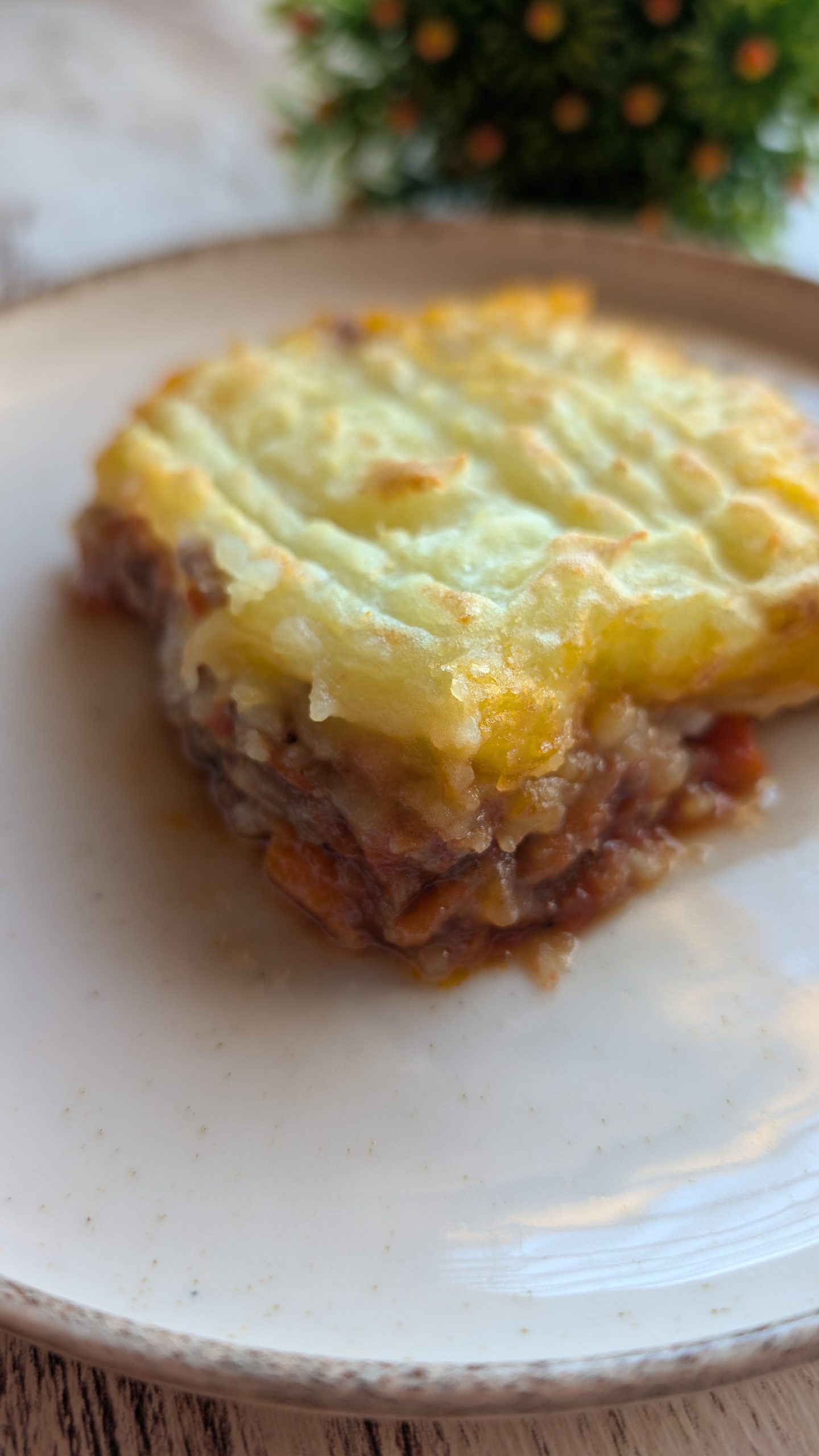 Pastel de carne picada y ragú de tomate cubierto con una capa de puré de patata gratinado en fuente de horno.
