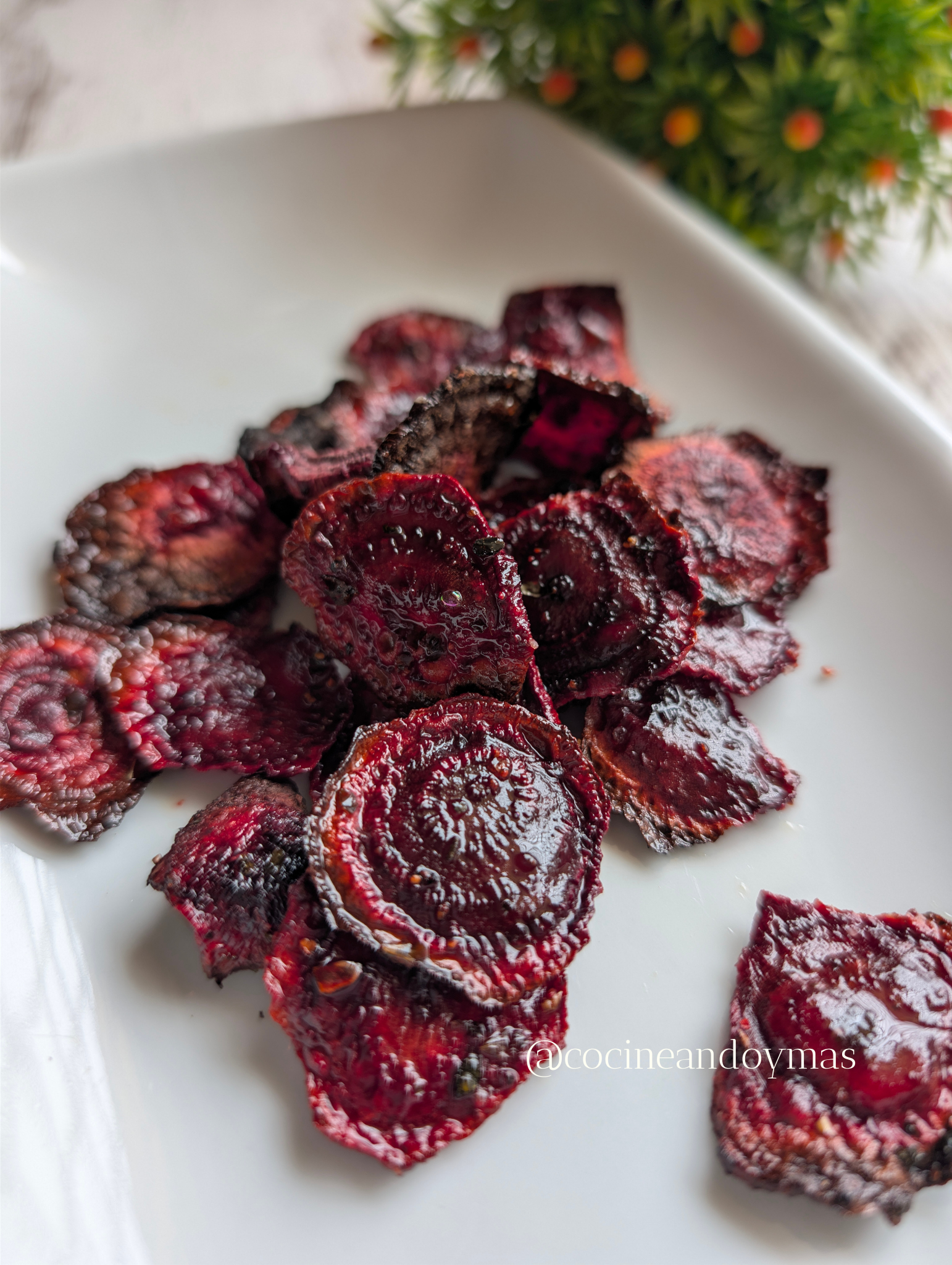 Chips de remolacha crujientes de color púrpura intenso en un cuenco de madera, preparados sin aceite.