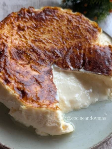 Tarta de queso pequeña cocinada en freidora de aire sobre papel de horno, con textura cremosa en el centro.