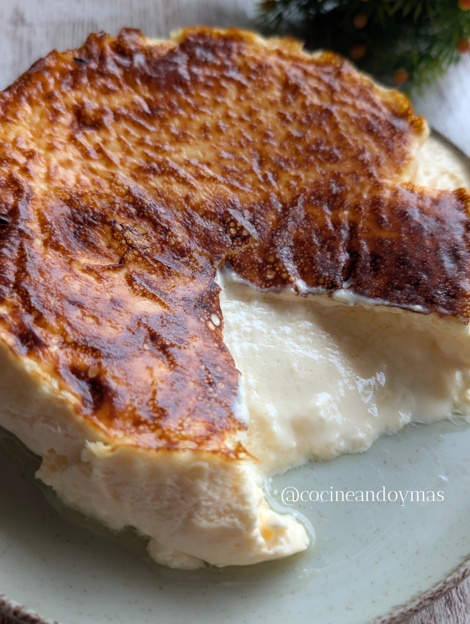 Tarta de queso pequeña cocinada en freidora de aire sobre papel de horno, con textura cremosa en el centro.