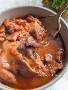 Plato hondo con callos y manitas de cerdo en una salsa espesa de tomate y pimentón con laurel.