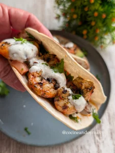 Tacos de tortilla de maíz rellenos de gambones a la plancha, pico de gallo con aguacate y salsa de yogur blanca.