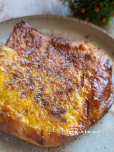 Rebanadas de pan brioche convertidas en torrijas doradas con canela, servidas en un plato rústico.