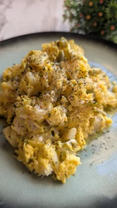 Plato hondo con revuelto jugoso de huevo, lascas de bacalao desalado, patatas y sofrito de cebolla, espolvoreado con perejil fresco.