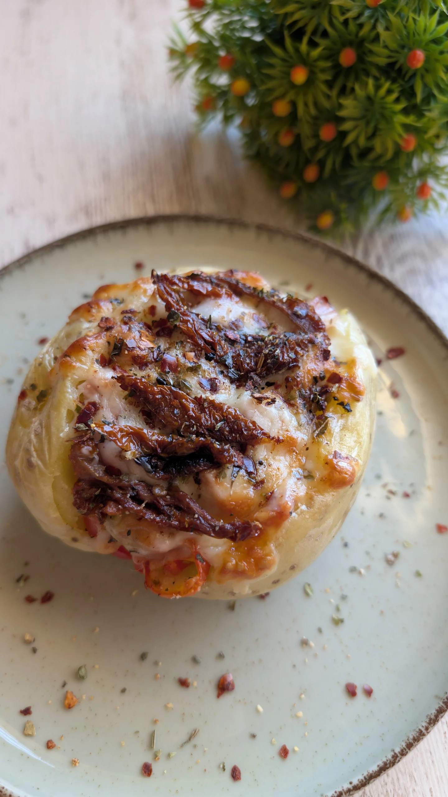 Mitades de patatas asadas y rellenas de pollo, tomates cherry y tomate seco, cubiertas con una capa gruesa de queso gratinado y dorado en airfryer.