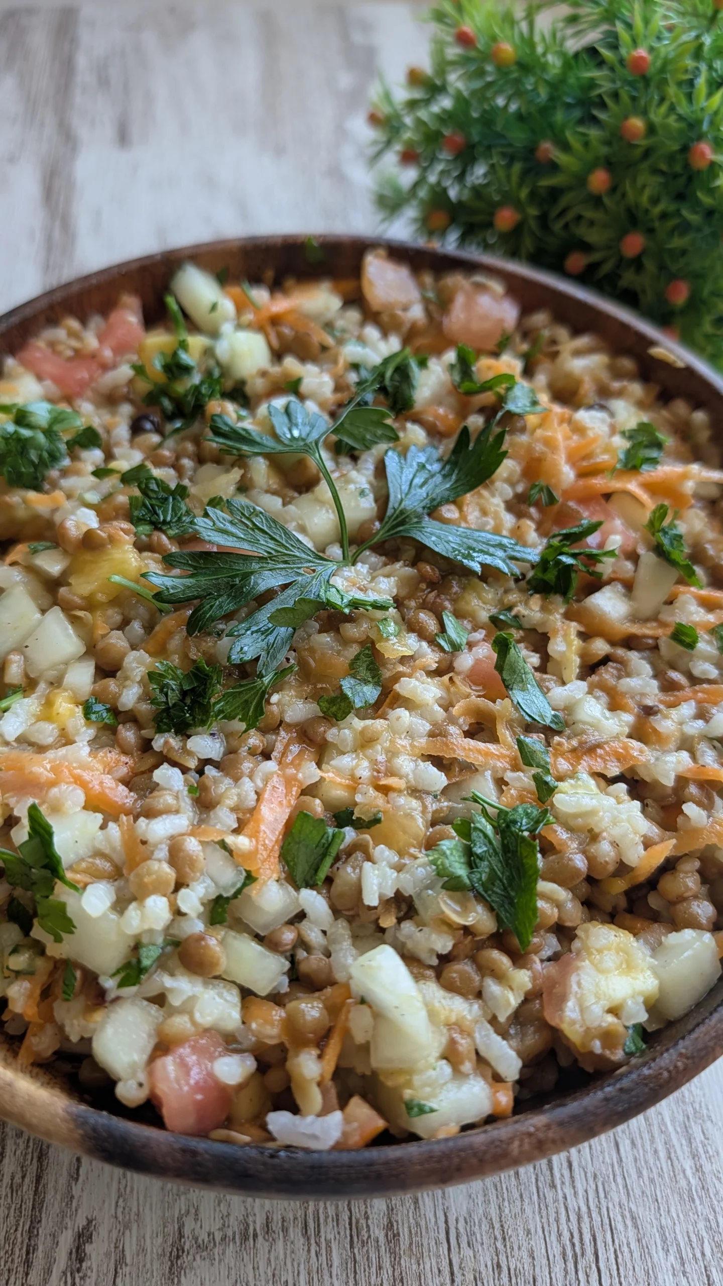 Bol de ensalada fría con lentejas, arroz cocido, dados de pepino, tomate, cebolla y mango, todo aliñado con una vinagreta de mostaza y perejil fresco.