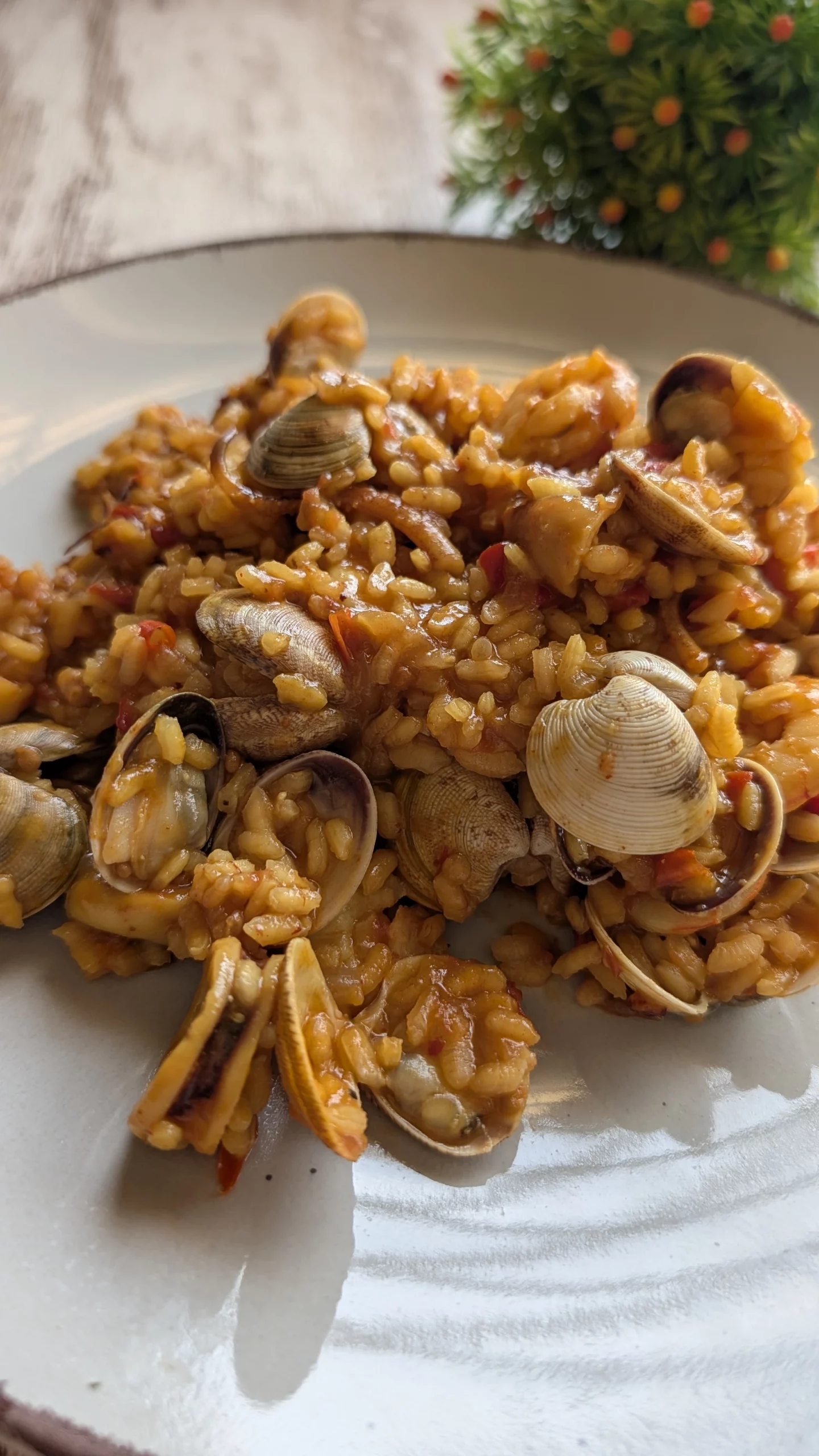 Cazuela con arroz marinero meloso decorado con almejas abiertas, gambas jugosas y trozos de calamar sobre un sofrito rojo de tomate y pimiento.