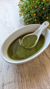Tarro de cristal con pesto de pistacho y albahaca fresca batido con aceite de oliva virgen extra, queso curado y pistachos enteros por encima.