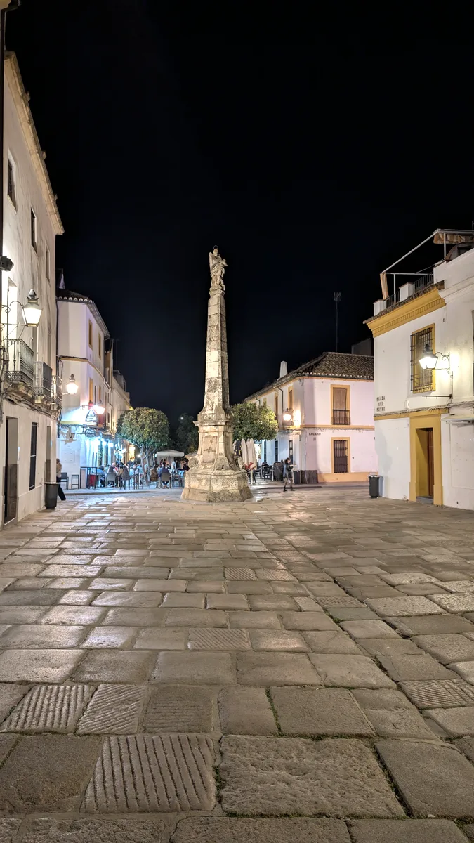 Plaza con monumento iluminada en Córdoba de noche