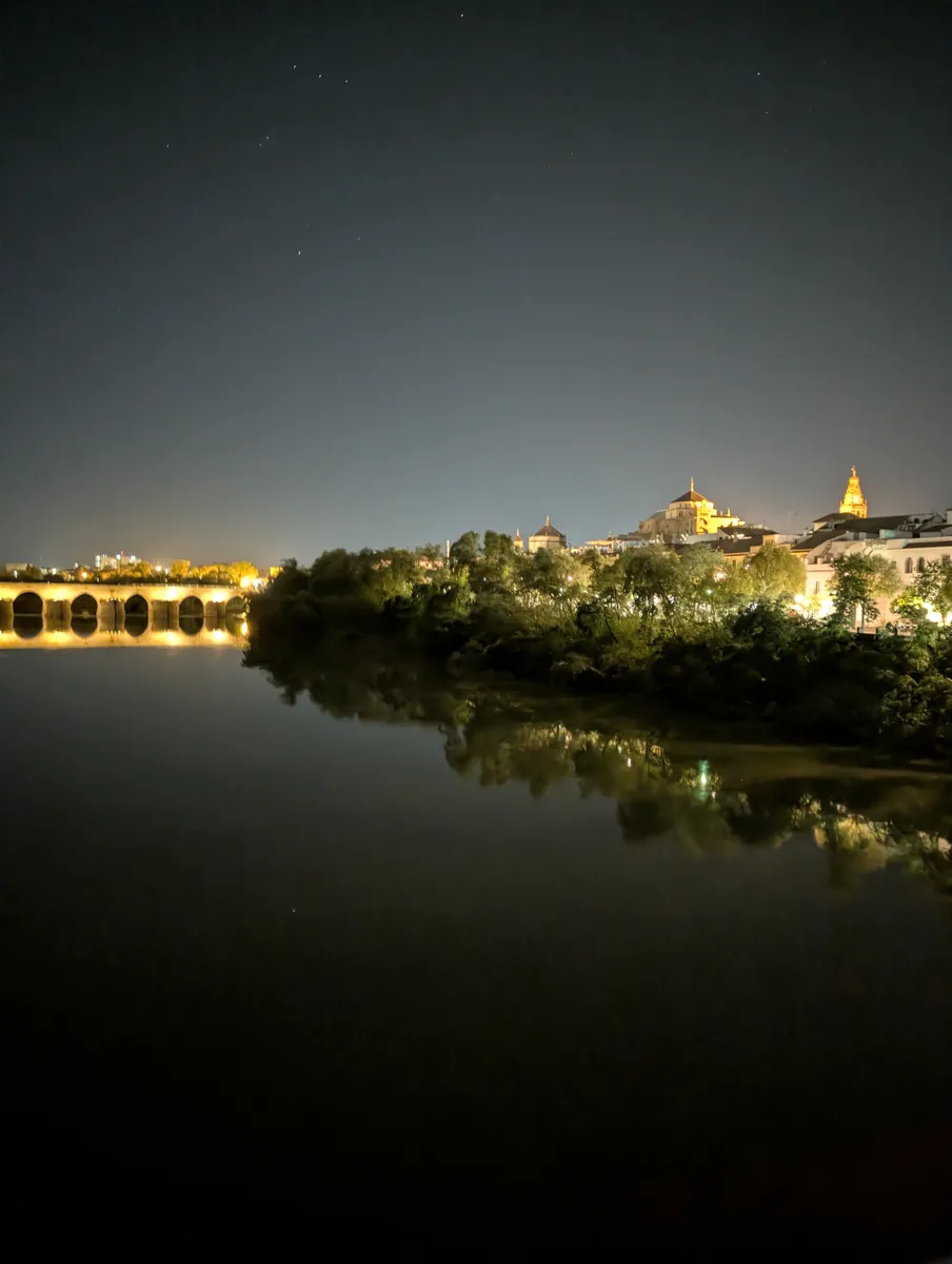La Mezquita-Catedral y el Puente Romano reflejados en el Guadalquivir de noche